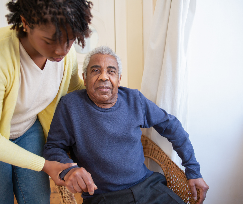 woman assists older man to sit more comfortably in a chair