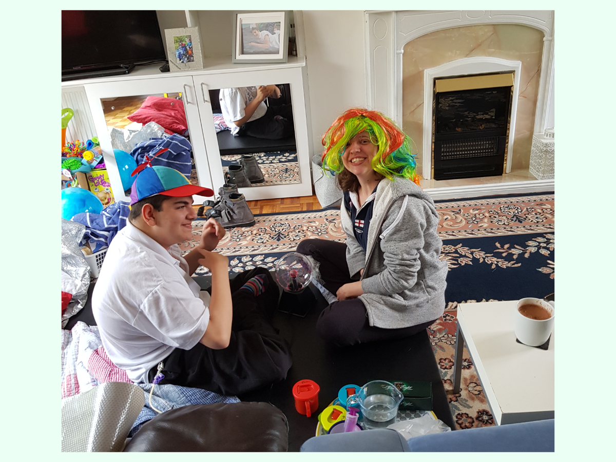 two people seated on the floor wearing funny hat and wig