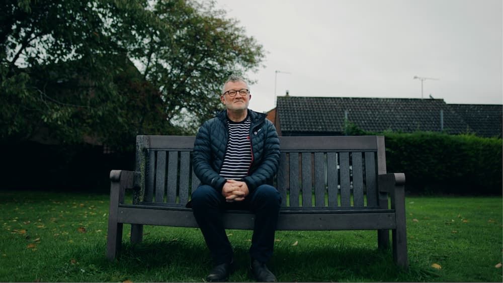 man sits alone on a park bench